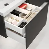 Stylish bathroom inspiration with beige vanity unit with inner drawer, upper cabinet, open shelf, oval mirror with lighting, matching pendants, shelf under the mirror, and wall-mounted toilet. Walls with light, elongated tiles
