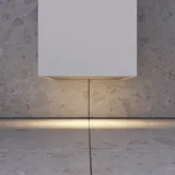 Small stylish bathroom with dark blue walls, soft yellow bathroom furniture with grooves, and an elegant round mirror with lamp
