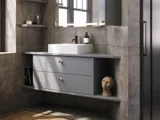 Bathroom inspiration with sloped walls inspiration, grey vanity unit and upper cabinet, custom-made countertops, modern square countertop basin, square mirror with lights, raw concrete walls and floors create an urban look