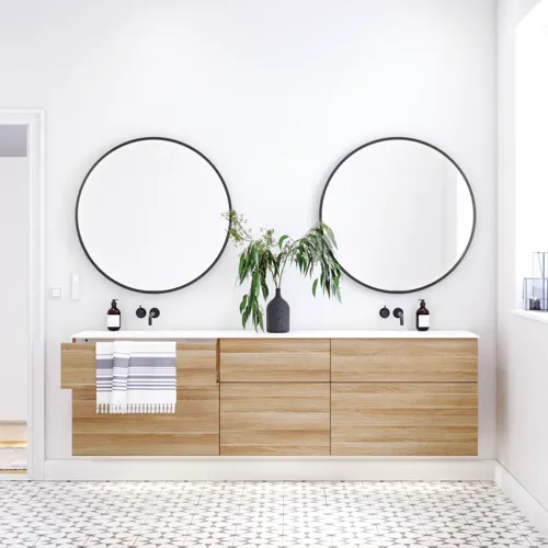 Nordic bathroom in wood finish with beautiful black framed round mirrors and plenty of storage in the furniture