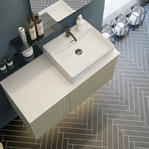 Bathroom with slanted ceiling inspiration, beige furniture with grooves, elegant countertop and square sink, beautiful mirror with shelves, blue walls, large windows, and black herringbone floor give a bright, urban look.