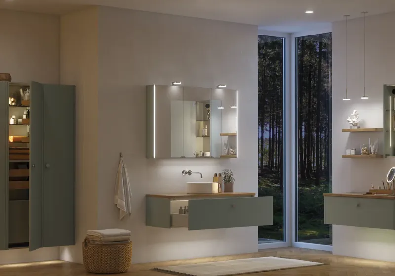Large bathroom inspiration in Nordic style with bathroom furniture in light blue colour and wooden countertop with elegant countertop basin, herringbone wooden floor creating a bright and classic style