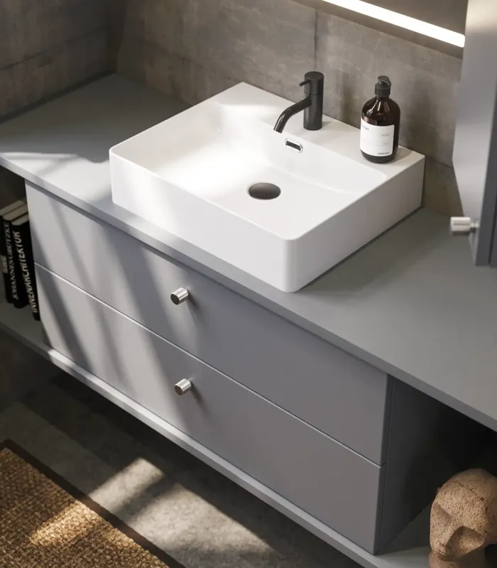 Bathroom inspiration with sloped walls inspiration, grey vanity unit and upper cabinet, custom-made countertops, modern square countertop basin, square mirror with lights, raw concrete walls and floors create an urban look