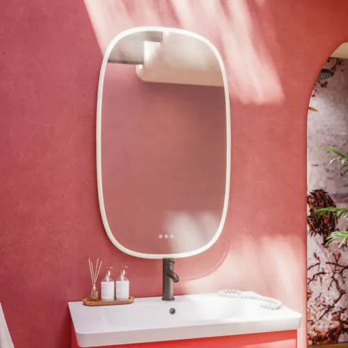 Bathroom inspiration with red walls, softly shaped red vanity and tall cabinet, elegant white sink and beautiful oval mirror with light, creating a vintage look together with the natural surroundings