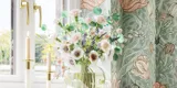 Bathroom inspiration with green special color bathroom furniture with natural oak sides, elegant grooves, stylish countertop with romantic oval countertop sink, beautiful oval mirror, combined with floral wallpaper gives a graceful, vintage retro look.
