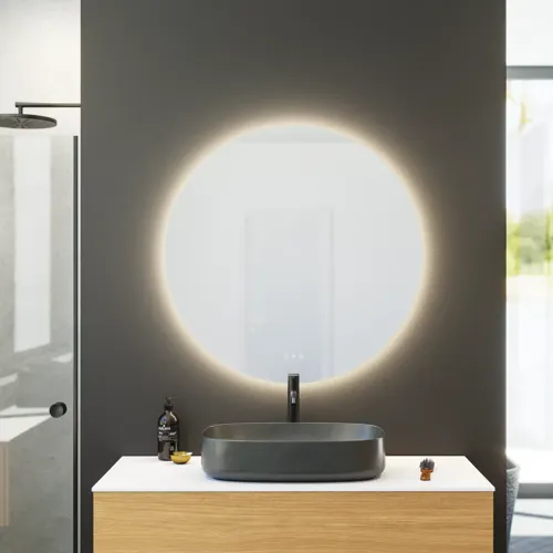 Minimalist and sleek bathroom inspiration with vanity unit, base cabinets, and tall cabinets in golden oak, large round mirror with light control, colored toilet, and countertop sink