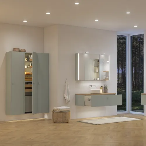 Large bathroom inspiration in Nordic style with bathroom furniture in light blue colour and wooden countertop with elegant countertop basin, herringbone wooden floor creating a bright and classic style