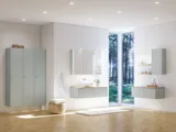 Large bathroom inspiration in Nordic style with bathroom furniture in light blue colour and wooden countertop with elegant countertop basin, herringbone wooden floor creating a bright and classic style
