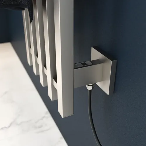 Electric towel rail on a dark blue wall in a stylish bathroom.