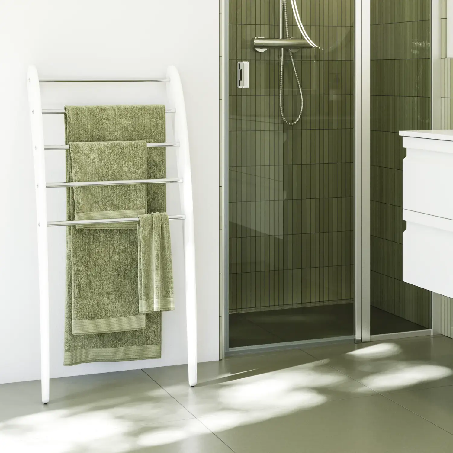 Bathroom inspiration with white bathroom furniture, elegant round mirror and shower niche with fixed shower wall with swing door in clear glass and profiles in satin, green oblong tiles give a sophisticated look.