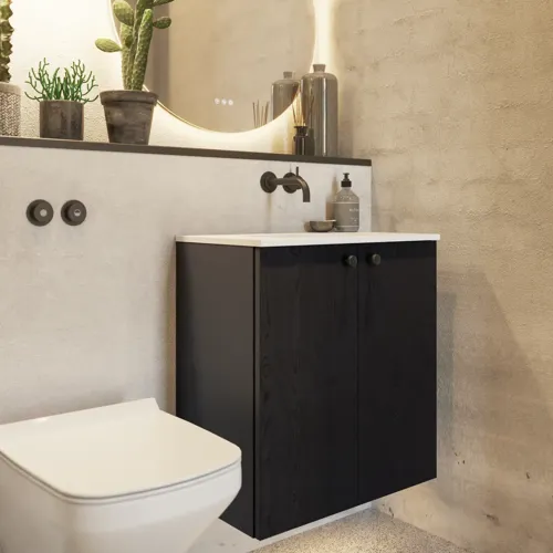 Bathroom inspiration with a black oak washbasin cabinet, an elegant round mirror and sink, stylish accessories, cactus plants, and walls in raw materials give a rough, industrial, and urban look.