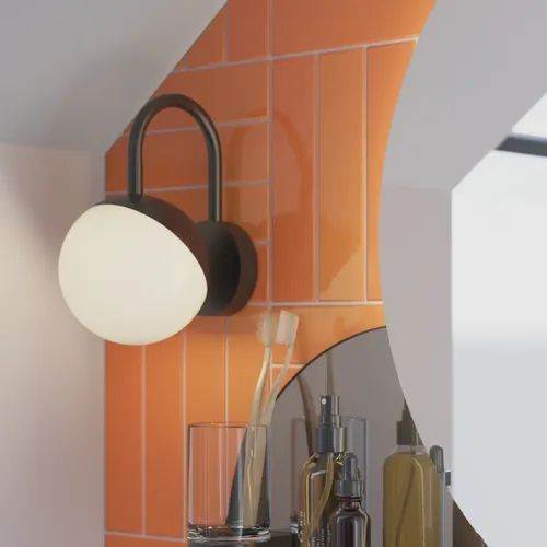 Bathroom with sloping ceiling inspiration with small white vanity unit and tall cabinet with round black handles, as well as beautiful round mirror, orange tiles give a fresh and modern look.