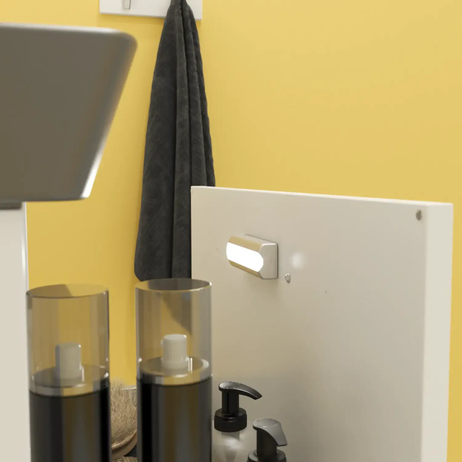 Small bathroom inspiration with a white vanity with black handle and black elegant sink, beautiful round mirror with black edge, offset wall cabinets, and terrazzo wall and floor, as well as yellow walls, provide a bold and modern look.