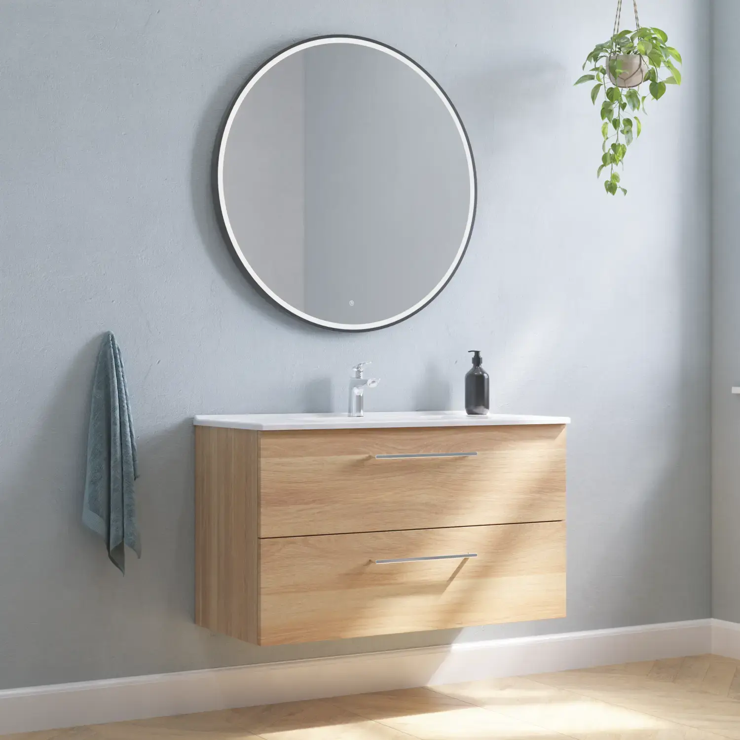 Large bathroom inspiration with vanity unit in Warm Oak with elegant washbasin, chrome handles and beautiful round mirror with black edge and light, herringbone floor and grey walls for a modern look.