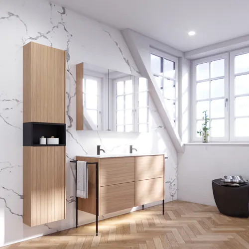 Bathroom inspiration with washbasin cabinets and wall cabinets in light oak with grooves, elegant double sink, beautiful mirror cabinet with light, herringbone floor in light wood, and white marble wall give a classic, bright, and sleek look.