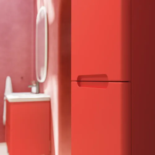 Bathroom inspiration with red walls, softly shaped red vanity and tall cabinet, elegant white sink and beautiful oval mirror with light, creating a vintage look together with the natural surroundings